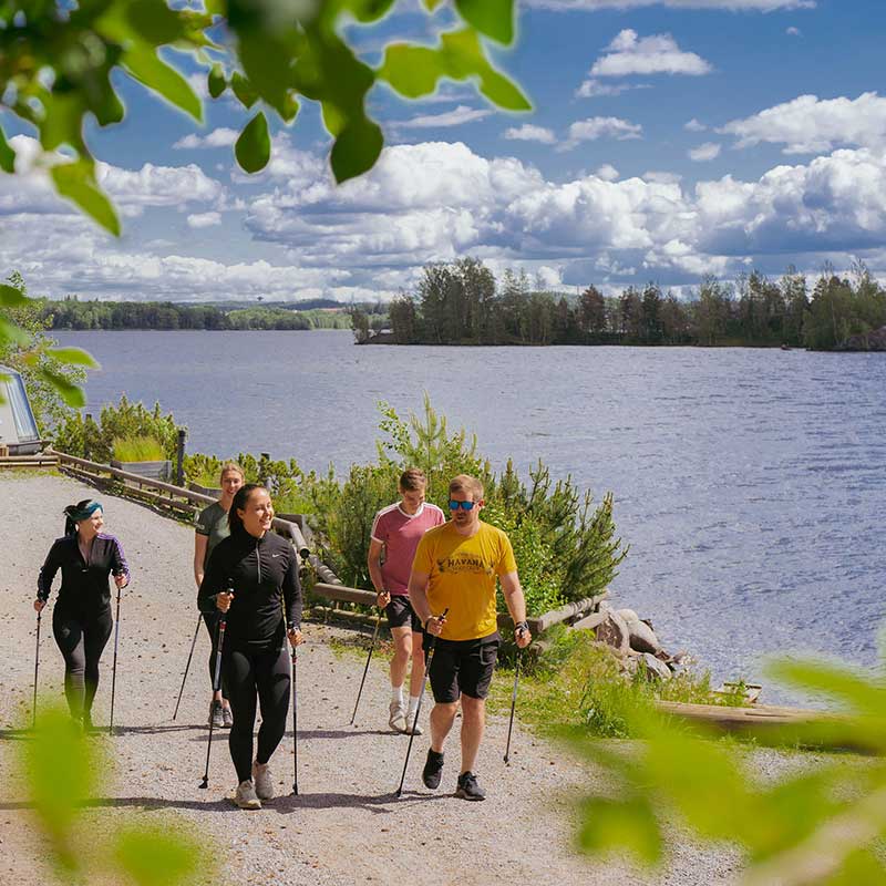 People enjoying a sunny lakeside walk