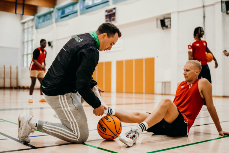 A trainer helping an injured basketball player